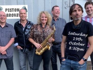 Promo slide for Piston Broke Live Music with 6 member band in daylight, staged group photo