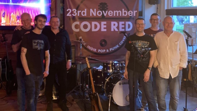 Six-piece band Code Red posing with instruments on stage for the photo